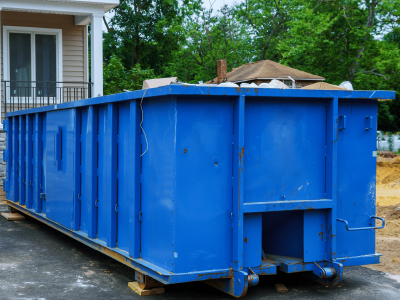 A blue colored dumpster of metal